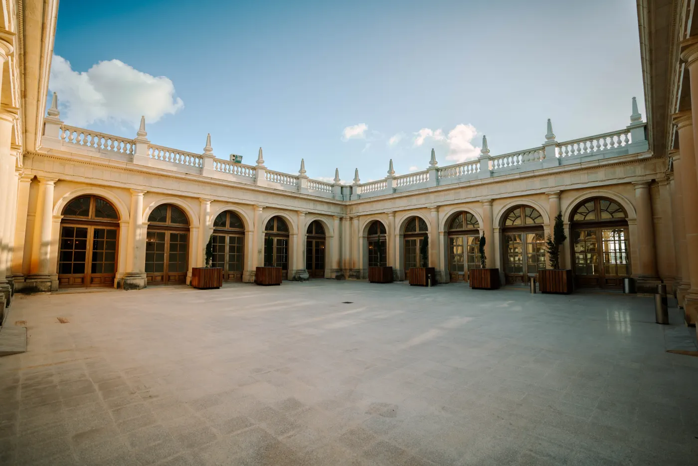 A rotating glimpse of the estate venues — courtyard, grand hall, gilded gallery and palm avenue