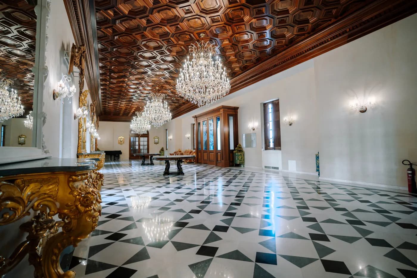 A rotating glimpse of the estate venues — courtyard, grand hall, gilded gallery and palm avenue